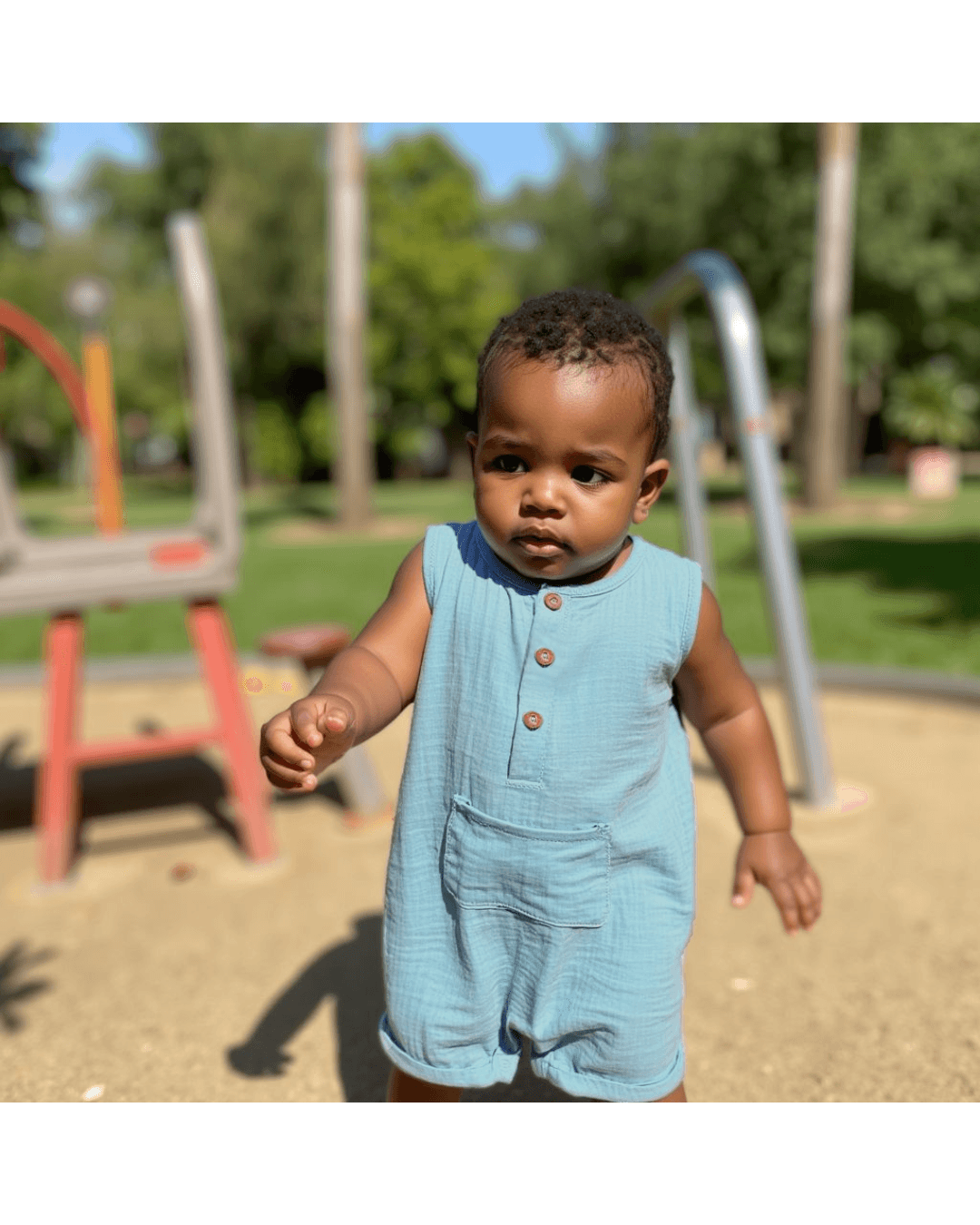 Baby in a blue muslin playsuit